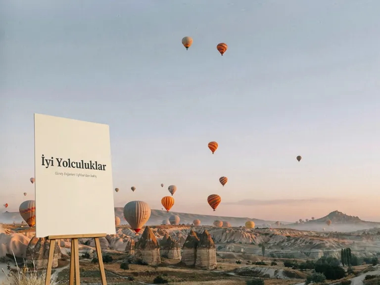 Balloons over Cappadocia and a poster that says 'İyi Yolculuklar'